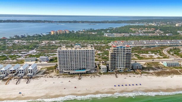 A beachfront hotel with multiple buildings, a sandy beach, and a view of the ocean. - Windemere 1103 | Beachfront | Seasonally Heated Pool | My Beach Getaways (Pensacola)