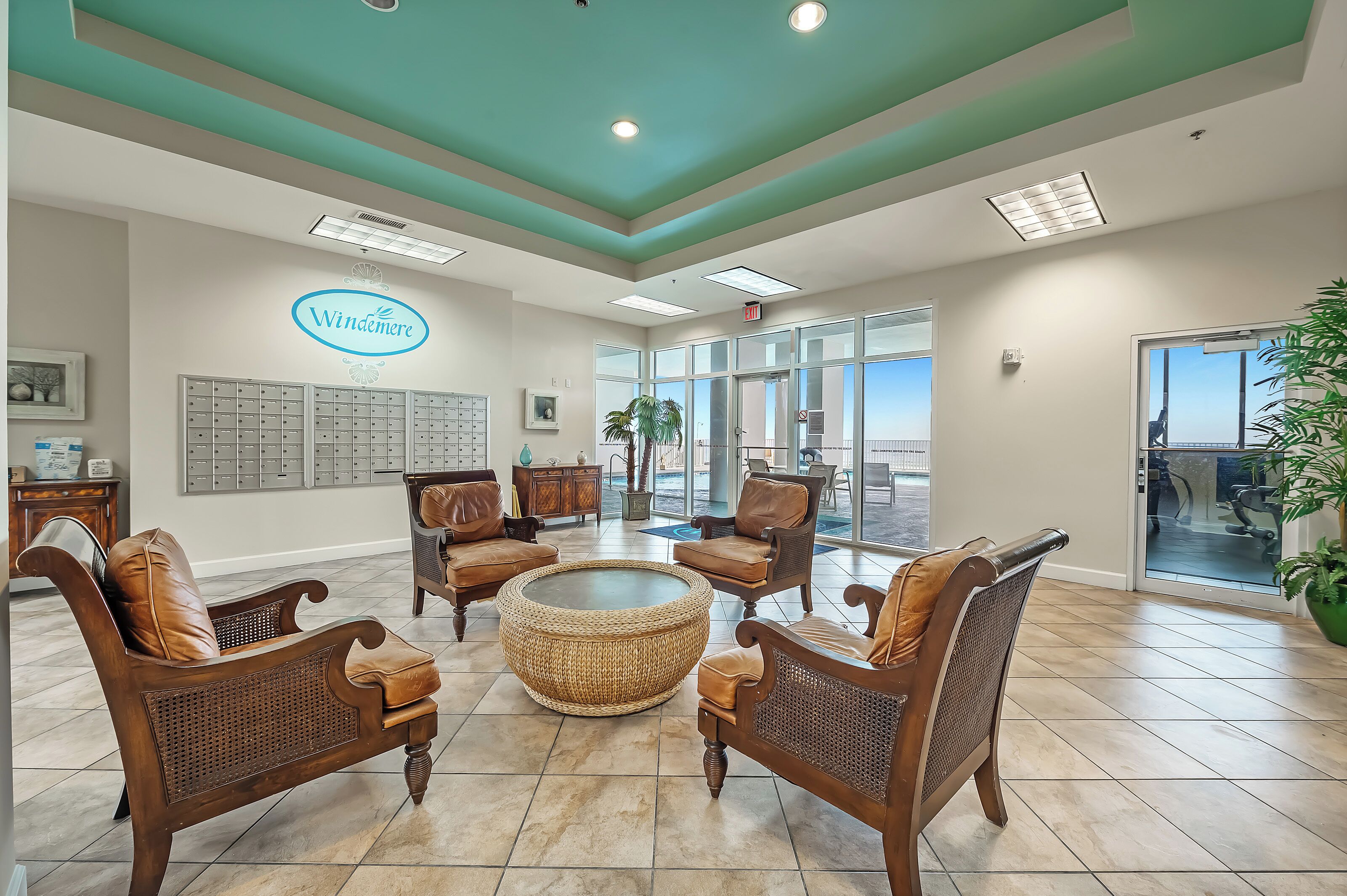 A reception area with a teal ceiling, a large reception desk, and a seating area with wicker furniture.