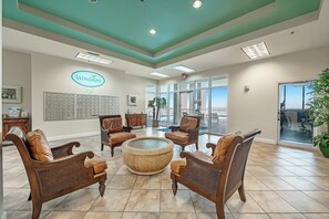 A reception area with a teal ceiling, a large reception desk, and a seating area with wicker furniture.