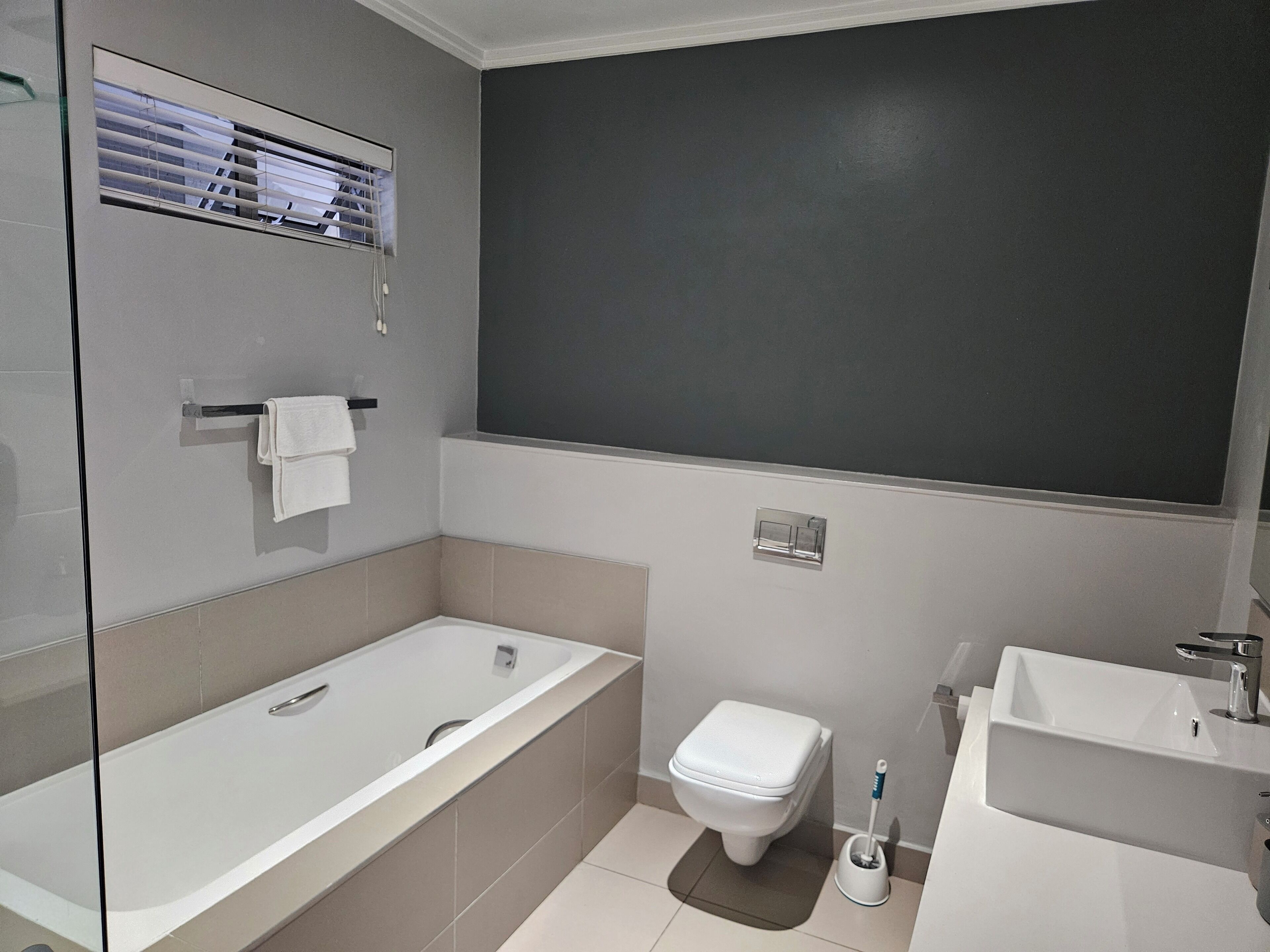 Ein modernes Badezimmer mit Badewanne, Toilette und Waschbecken.