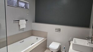Une salle de bain moderne avec une baignoire, des toilettes et un lavabo.