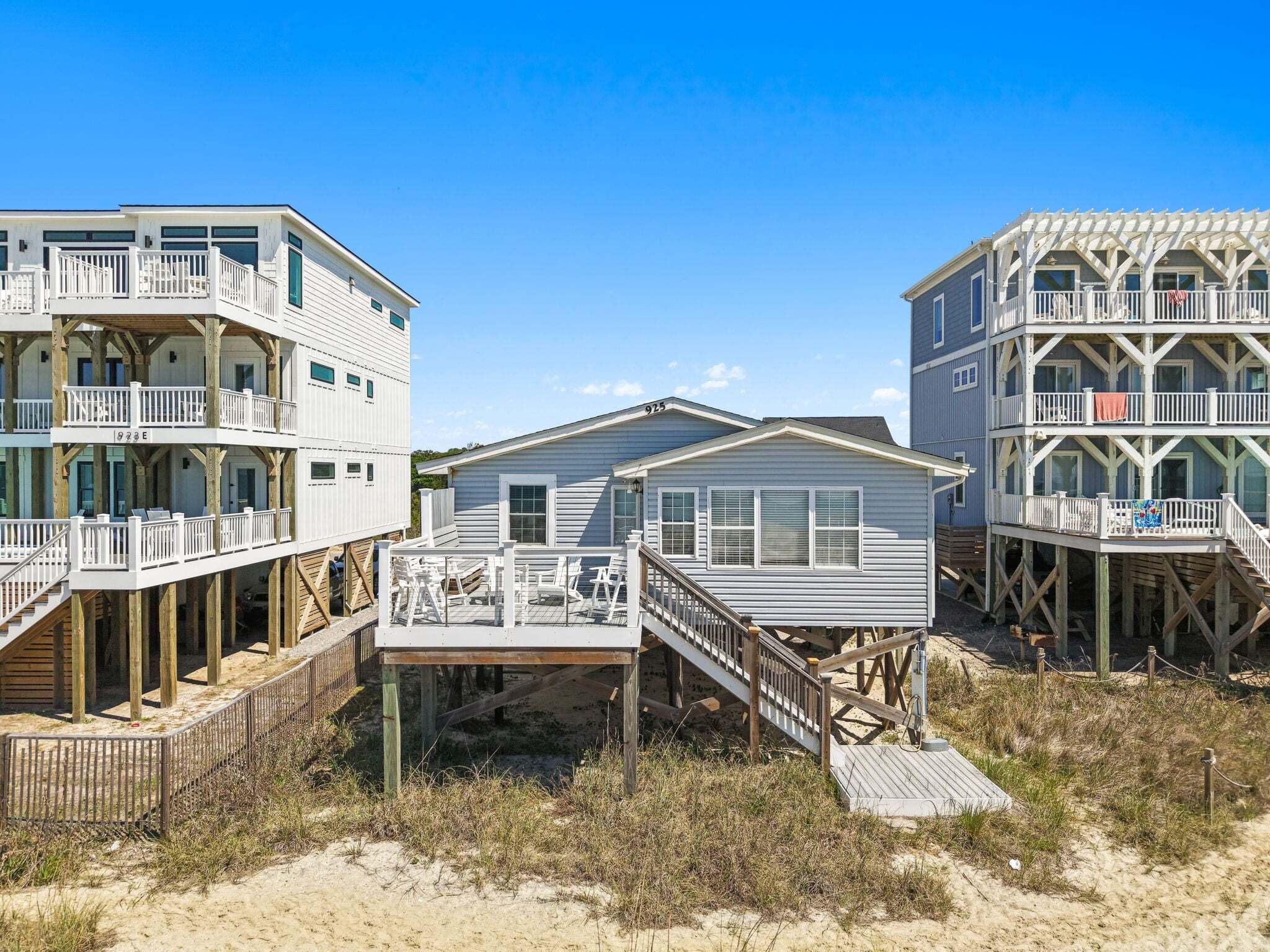 Ein Strandgrundstück mit mehreren Ebenen, Holzdecks und einer Sandbucht.