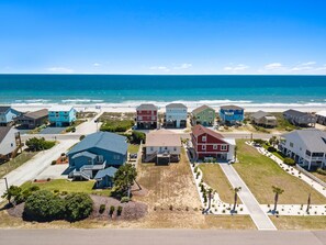 Une zone résidentielle côtière avec des maisons, une plage et un ciel dégagé.