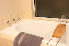 A bathroom with a bathtub, a wooden tray, and a glass of water. - Duble Room Near Stunning Beaches in quaint Baldivis (Baldivis)