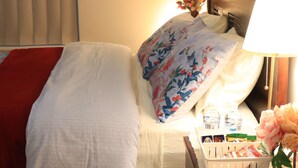 A hotel room with a bed, a nightstand with a lamp, a vase with flowers, and a wall-mounted picture. - Duble Room Near Stunning Beaches in quaint Baldivis (Baldivis)