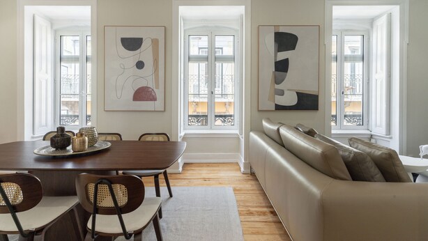 Un área de comedor con una mesa, sillas y un sofá.