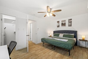 A bedroom with a bed, a ceiling fan, a bedside table with a lamp, and a door leading to a closet. - Pet-Friendly Montrose 1BR | Museums| Free Parking newly renovated M2 (Houston)