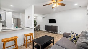 Ein modernes Apartment mit Küche, Essbereich und Wohnzimmer.