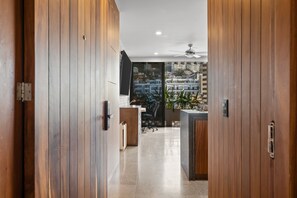 A modern kitchen with wooden cabinets, a built-in oven, and a large window overlooking a cityscape. - Casa Soul | Stylish 1-Bedroom in Zona Romántica (Puerto Vallarta)