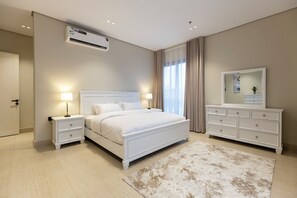 A bedroom with a bed, nightstands, a dresser, an air conditioner, and a window with curtains. - Timeless Elegance And Comfort Redefined (Madinah)