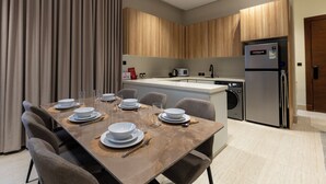 Een moderne keuken met een vast eiland, roestvrijstalen apparatuur en een eethoek voor zes personen.