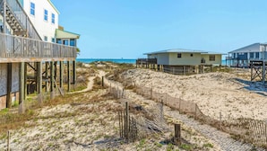 A beachfront property with a wooden deck, a sandy path, and a view of the ocean. - Mac's Crab Shack | Ocean Views | Great Location (Dauphin Island)