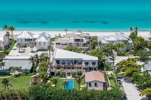 Un hôtel situé sur la côte, composé de plusieurs bâtiments, doté d’une piscine et offrant une vue sur la plage.