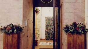 Un pasillo con un cartel que dice '30' y una puerta que da a una habitación con pared verde.