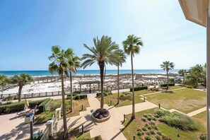 A beach view with palm trees, a pathway, and a seating area. - 2BR Beach Condo, Shared Pool, Tennis Courts (Gulf Shores)