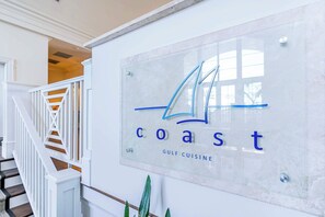A sign with the word 'coast' and 'Gulf Cuisine' on a wall. - 2BR Beach Condo, Shared Pool, Tennis Courts (Gulf Shores)