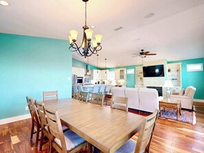 Amplia sala de estar con mesa de comedor, sillas, sofá y televisor.