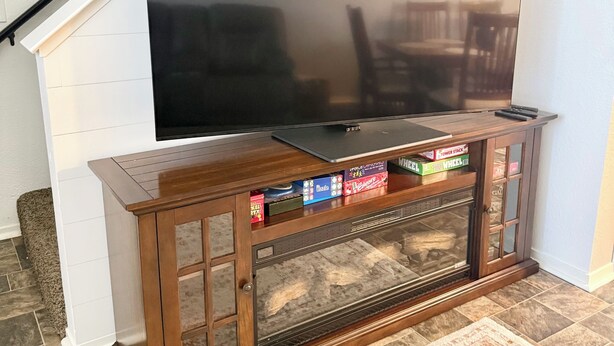Un mueble de madera con un televisor de pantalla plana, una chimenea y una alfombra.