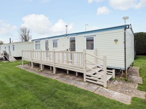 A mobile home with a porch and steps leading to the entrance. - Sealands Ingoldmells (Skegness)