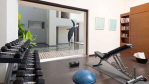 Een sportschool met trainingsapparatuur, een blauwe trainingsbal en een waterpartij.