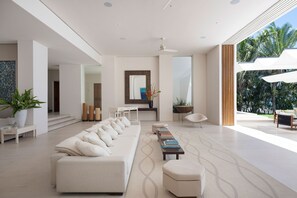 A modern living room with a sofa, coffee table, and a view of the outdoors. - Estate Buho in Punta Mita (Punta de Mita)