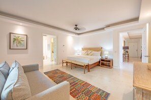A bedroom with a bed, bedside tables, a sofa, and a colorful rug. - Condo Zazil in Punta Mita (Punta de Mita)