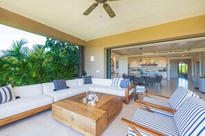 A modern living room with a sofa, coffee table, and striped sofa set. - Condo Zazil in Punta Mita (Punta de Mita)