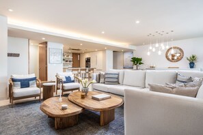 Ein modernes Wohnzimmer mit einer Couch, Sesseln, einem Couchtisch und einem Essbereich.