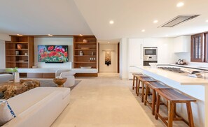 A modern living room with a sofa, wooden coffee table, and a painting on the wall. - Condo Nova in Punta Mita (Punta de Mita)