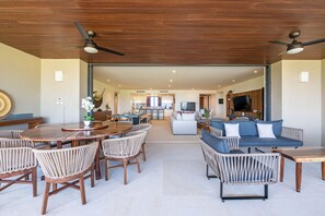 A spacious living area with a dining table, chairs, a sofa, and a television. - Condo Bah a in Punta Mita (Punta de Mita)