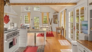 A spacious kitchen with white cabinetry, a large island, and a water dispenser. - Waterfront lodge on 24 acres with patio & fireplace (Rhododendron)
