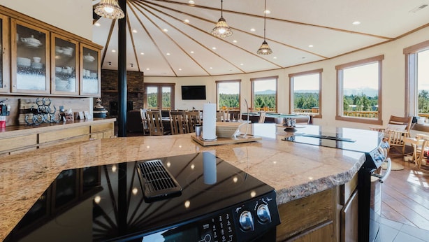 Una cocina amplia con una isla grande, armarios de madera y un techo alto con vigas a la vista.