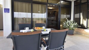 An outdoor seating area with a table and chairs, a bowl of fruit, and a potted plant. - Premium Stay With Terrace and BBQ (Umag)