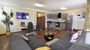 A modern living room with a sofa, a glass coffee table, and a TV. - Premium Stay With Terrace and BBQ (Umag)