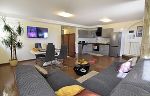 A modern living room with a sofa, a glass coffee table, and a TV. - Premium Stay With Terrace and BBQ (Umag)