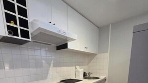 Een moderne keuken met witte kastjes, een zwart fornuis en een ingebouwde oven.