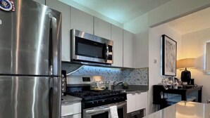 Une cuisine moderne équipée d’appareils électroménagers en acier inoxydable, d’un four à micro-ondes et d’une cuisinière à gaz.