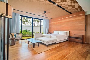 A modern bedroom with a large bed, a sofa, a coffee table, and a wooden floor. - Banyan Tree Grand Residences by Banyan Living (Choeng Thale)