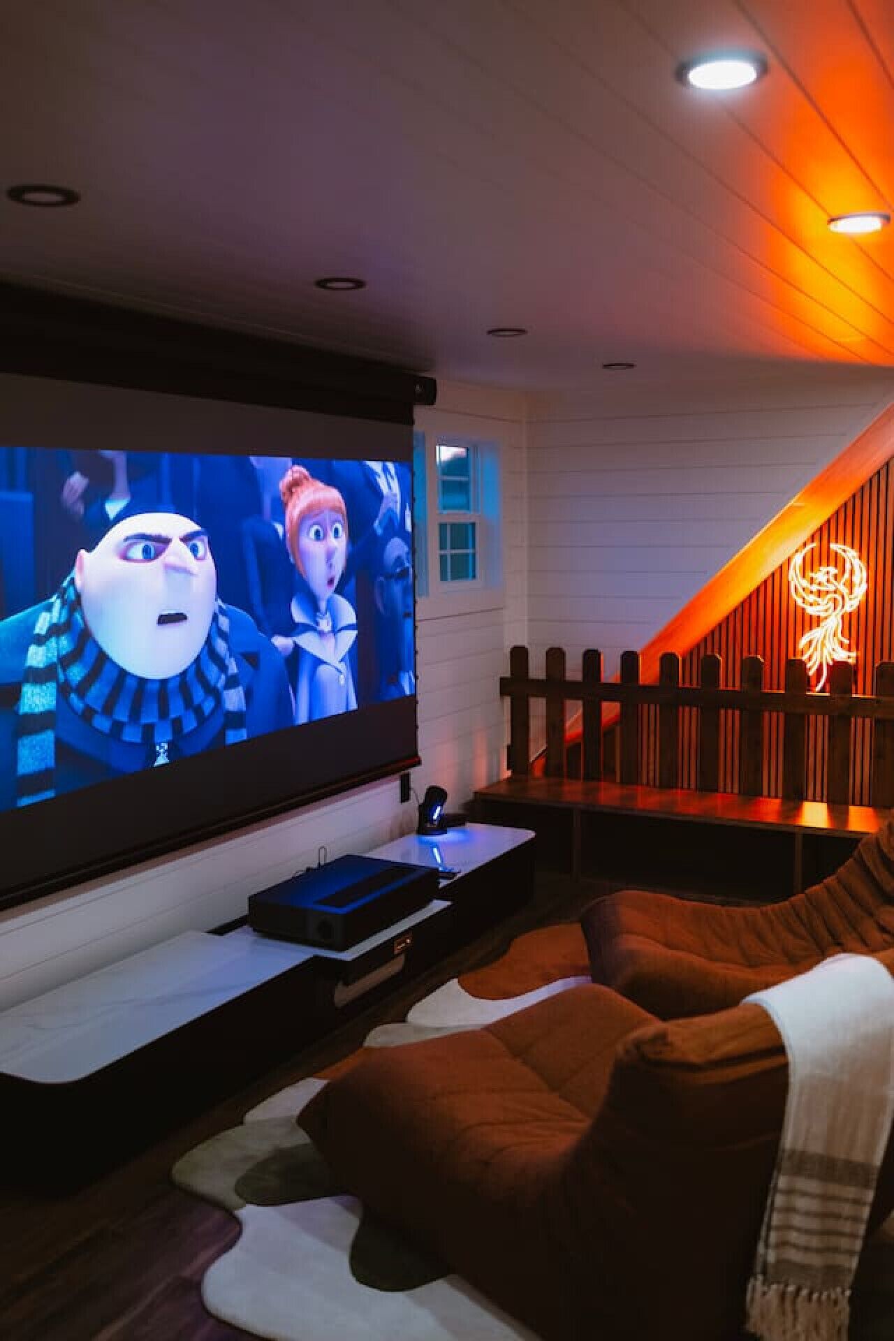 A home theater setup with a large TV, a gaming console, and a cozy seating area.