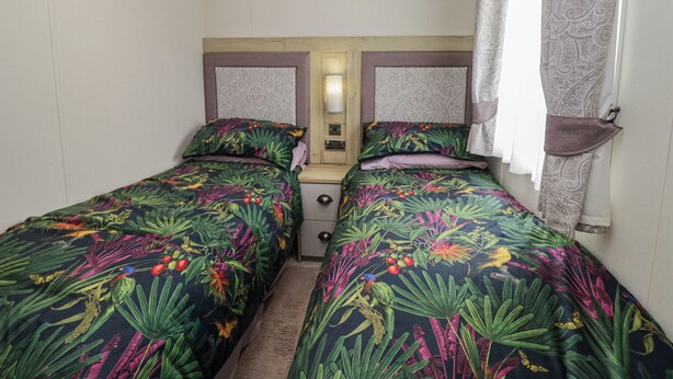 A room with two single beds, a bedside table, and a wardrobe. - Carp Lodge (Carnforth)