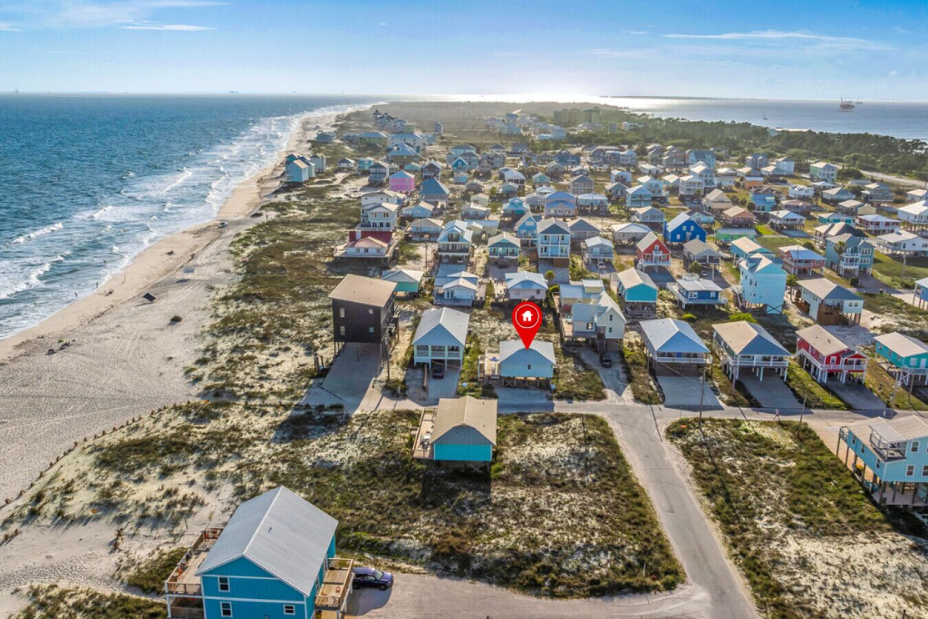 Uma região costeira com várias casas, uma praia e um corpo de água.