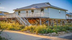 Une maison avec un balcon, un escalier et une terrasse en bois.