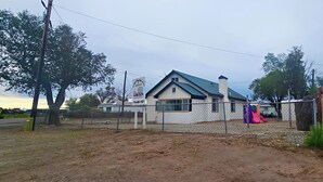 A fenced property with a building, a playground, and a signboard.