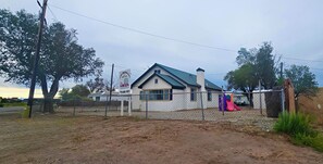 A fenced property with a building, a playground, and a signboard. - Downtown home family and pets. (Alamosa)