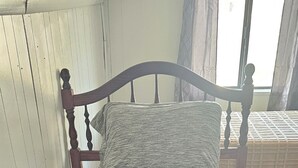 Un lit avec une couvre-lit bleu foncé, une tête de lit en bois et un oreiller.