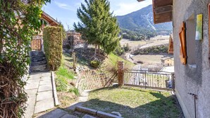 Ein Balkon mit Blick auf ein Tal, eine Steintreppe und ein Holzzaun.