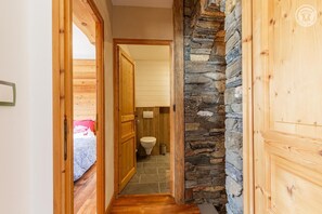 A narrow hallway leading to a bathroom with a stone wall and wooden door. - L'entre Deux - VAL CENIS (VAL CENIS)