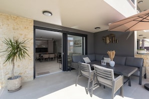 An outdoor seating area with a table, chairs, and a large umbrella. - Apartment Apartman Carolina (Istria - Novigrad) (Novigrad)