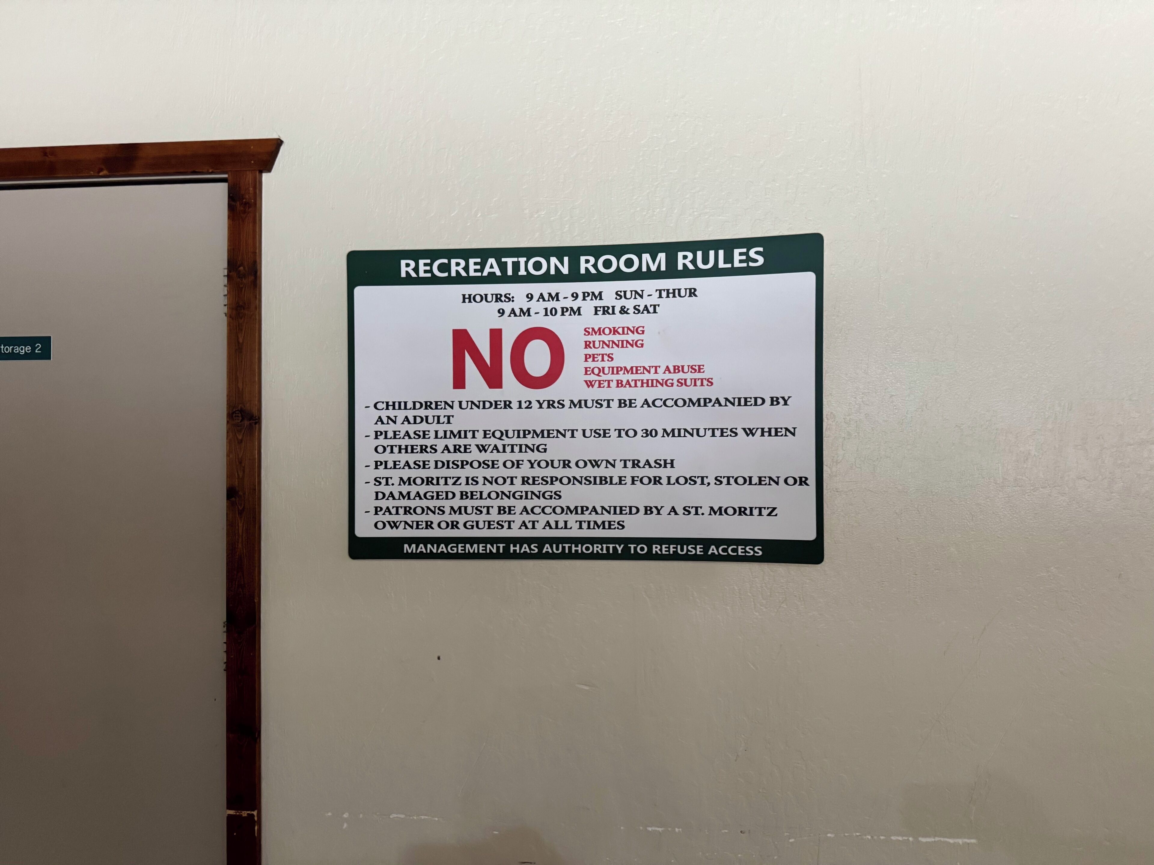 Schild mit Regeln für den Aufenthaltsraum, darunter Öffnungszeiten, Rauchverbot, kein Laufen, keine Haustiere, keine Beschädigung der Geräte und keine naschen Badeanzüge.