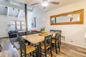 A dining area with a wooden table, chairs, and a ceiling fan. - Centrally Located Townhouse - Jacuzzi & Parking! (Mammoth Lakes)